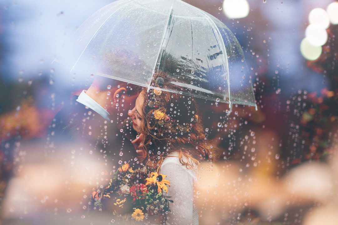 Young couple under umbrella in the rain
