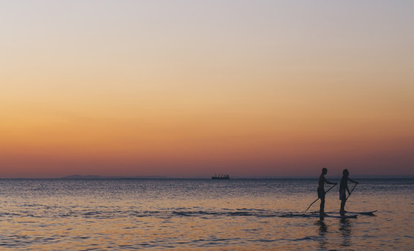 People paddleboarding during the golden hour