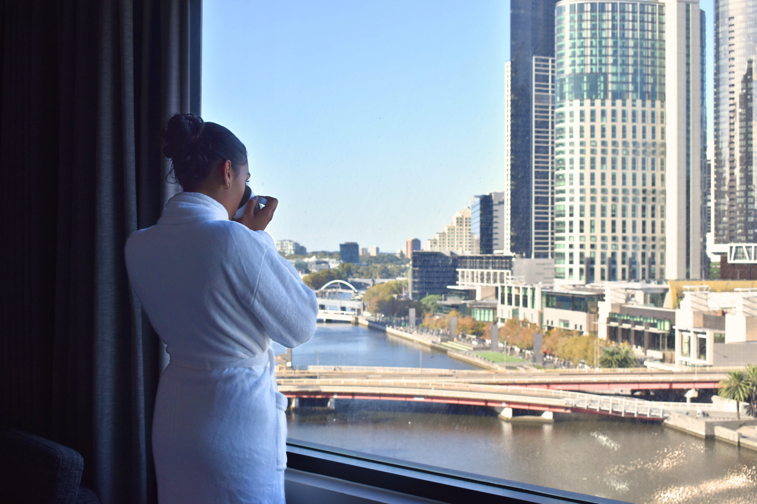 A woman enjoying city views from the King Casino River View Rooms